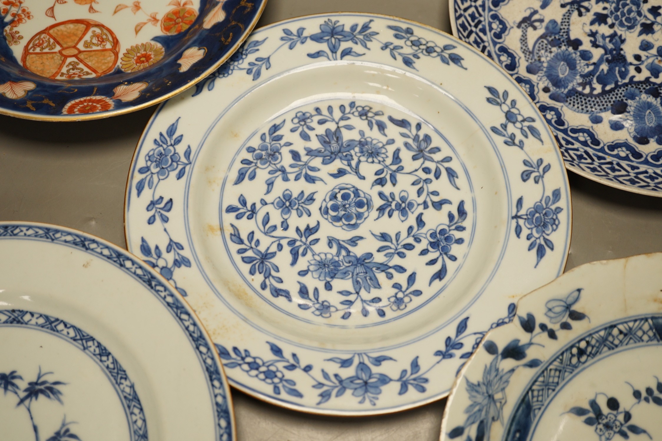 Four Chinese 18th century plates and a late 19th century blue and white dragon plate, largest 24cm diameter